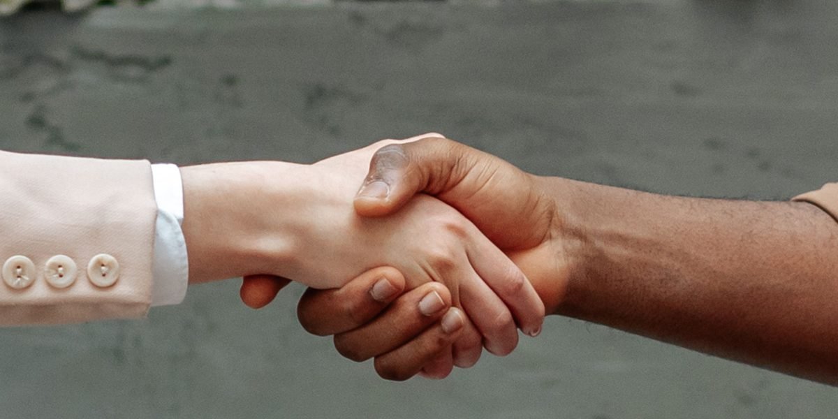 Professionals engaged in a focused discussion, shaking hands after reaching an agreement.