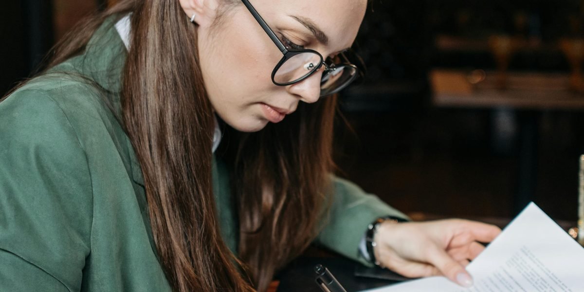 A person focused on preparing documents, symbolizing the dedication needed for a competitive job application.