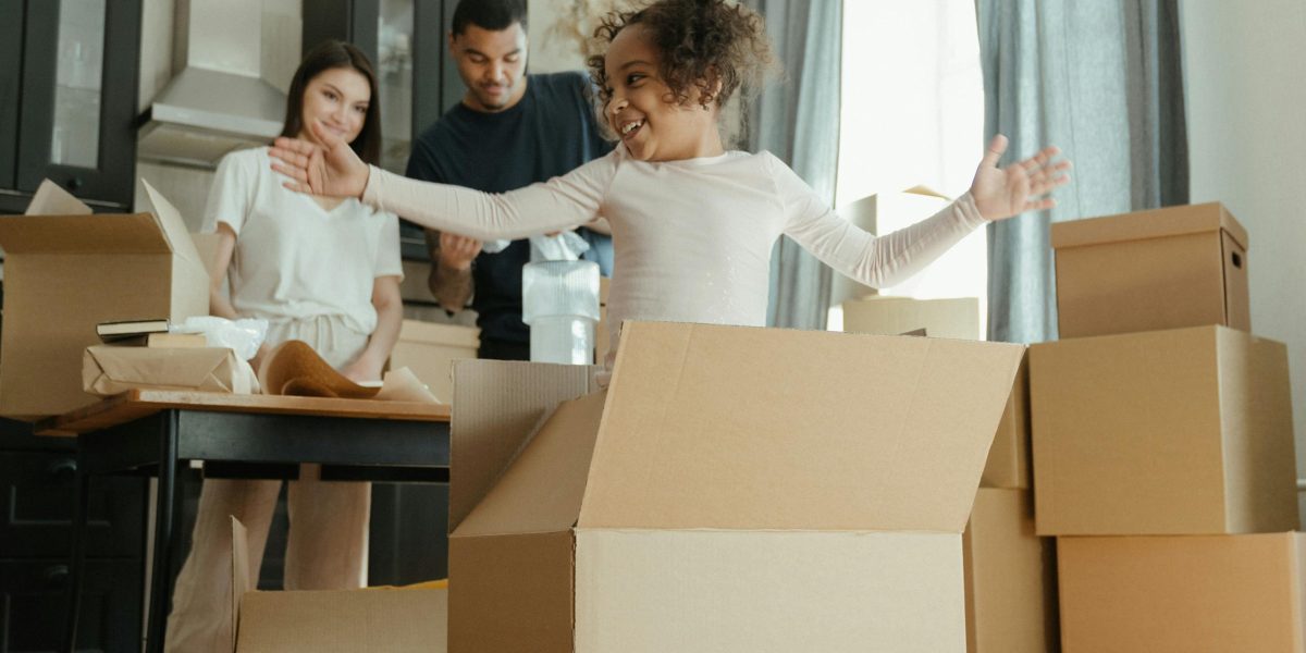 A happy family arriving at their new home, ready to start a new chapter in a different city.