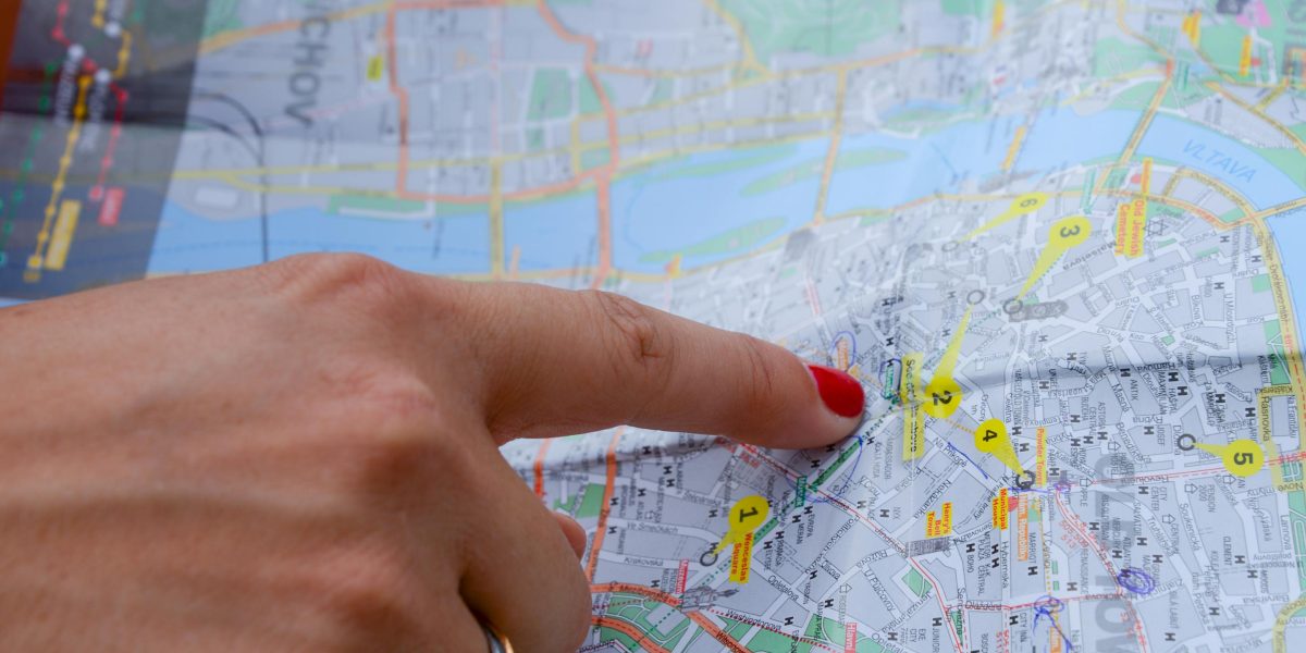 A person thoughtfully reviewing a city map, symbolizing the challenge and excitement of finding a new neighborhood in a growing city.