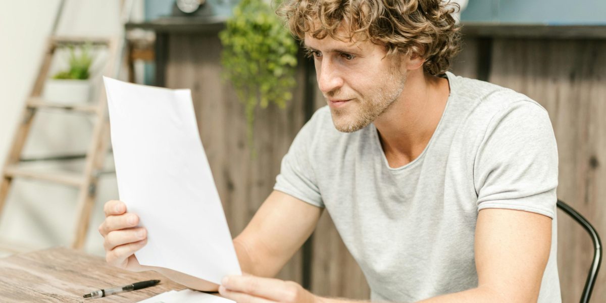 A person intently reviewing documents, symbolizing the crucial decision-making process when choosing a property agency.