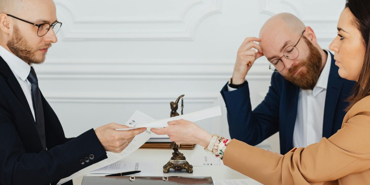 Two people in conversation, reviewing documents and seeking expert advice on legal matters or investments.
