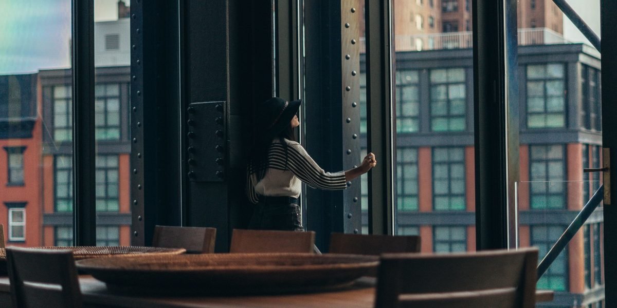 A person stands on a balcony, gazing at a stunning Dubai skyline and tranquil waters, reflecting luxury living.