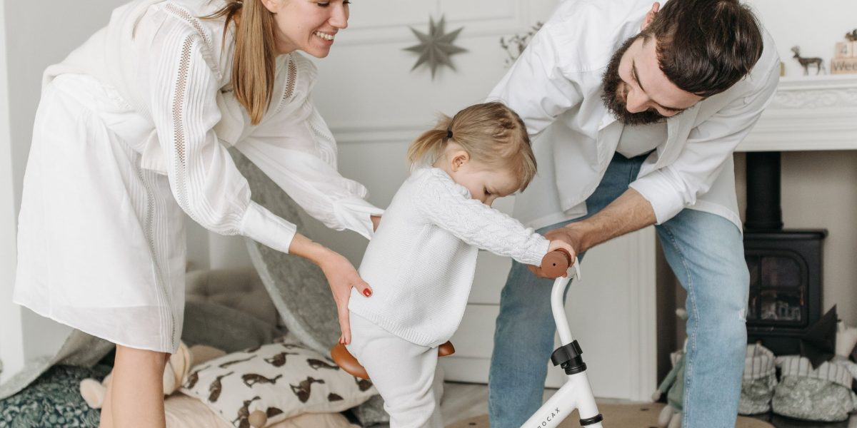 A happy family with a child playing together in a spacious living area, illustrating the benefits of a two-bedroom flat for growing families.