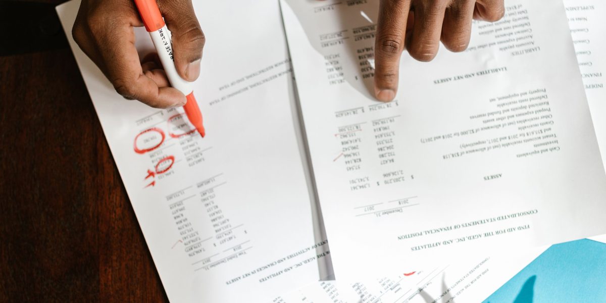 A person thoughtfully reviewing documents, symbolizing the need for clear strategy in complex markets.