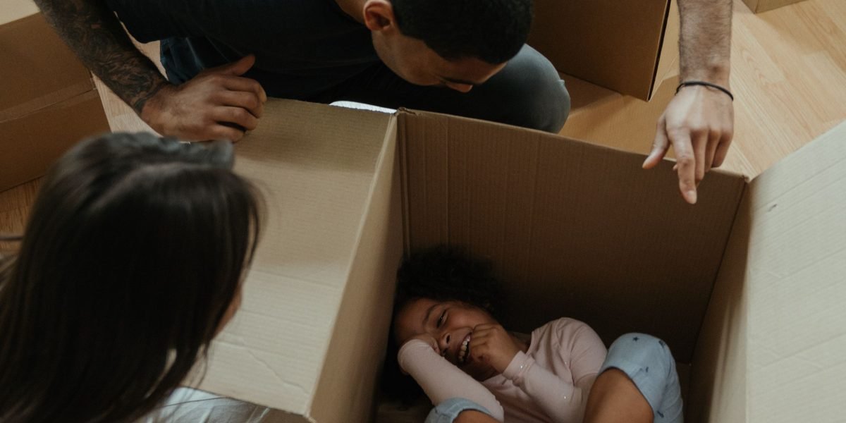 A joyful family celebrates their successful move, surrounded by boxes in their newly acquired luxury home.