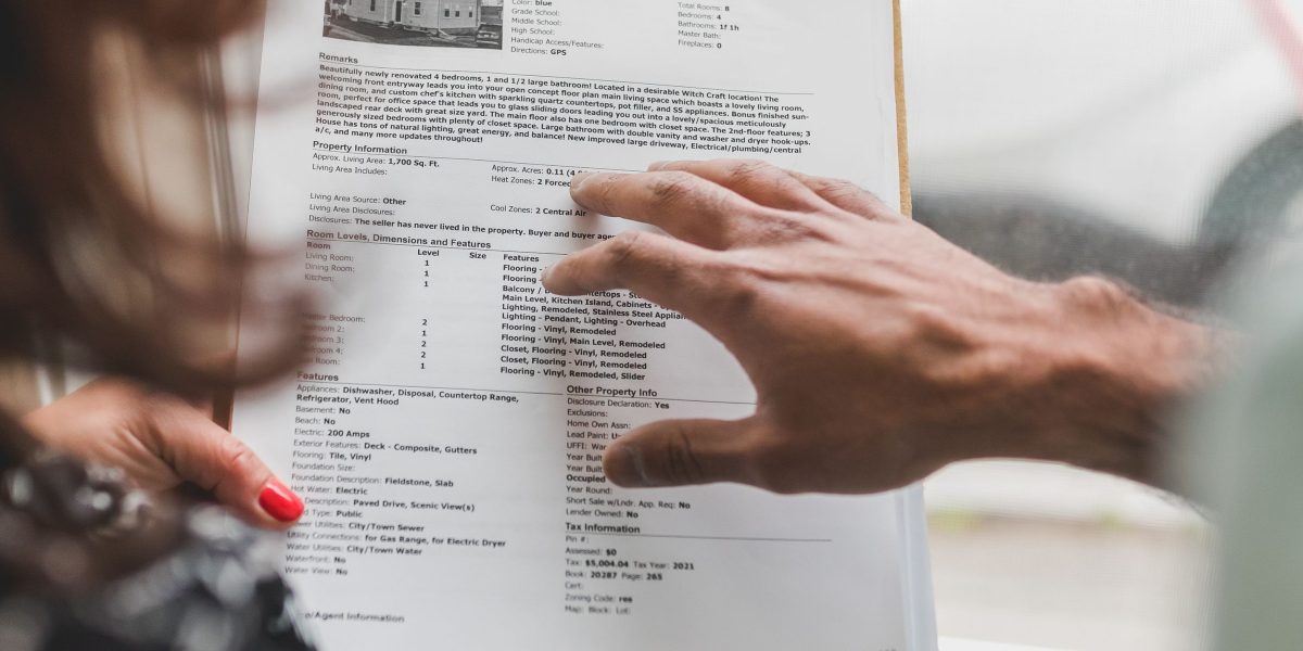 An experienced property consultant guiding a client through important documents and market insights.