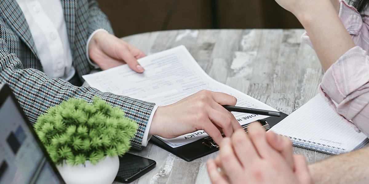 Professionals finalizing a property deal by signing documents, representing the crucial step of ownership transfer.