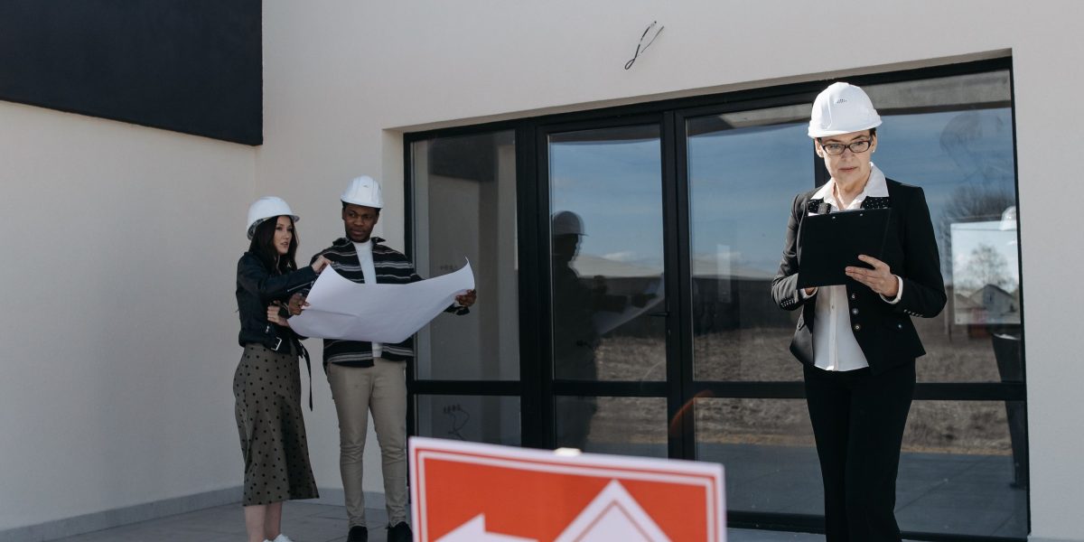 Professionals reviewing documents and plans related to property investment strategy.