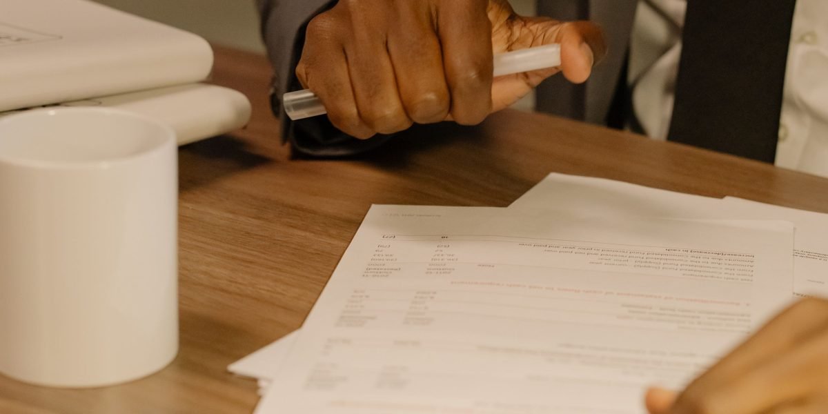 A person diligently reviewing documents, symbolizing thorough due diligence in choosing a broker.
