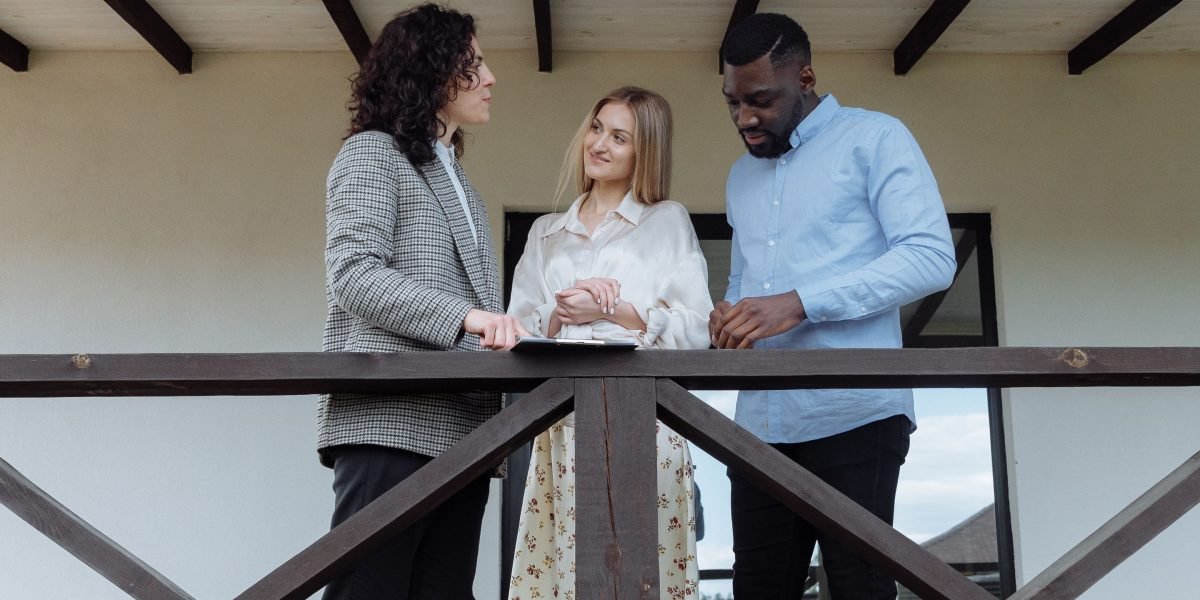A group of people discussing different neighborhood options for a 4-bed villa in Dubai, considering family needs, luxury, and investment potential.