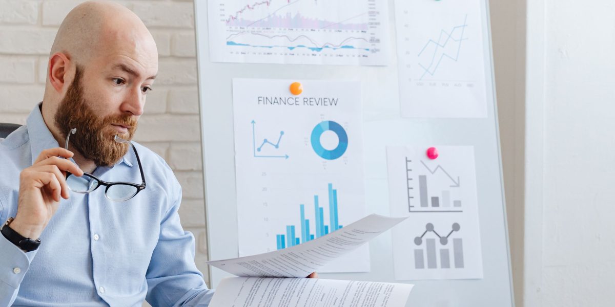 A person meticulously reviewing financial documents and calculations, planning the financing and potential ROI for a property investment.