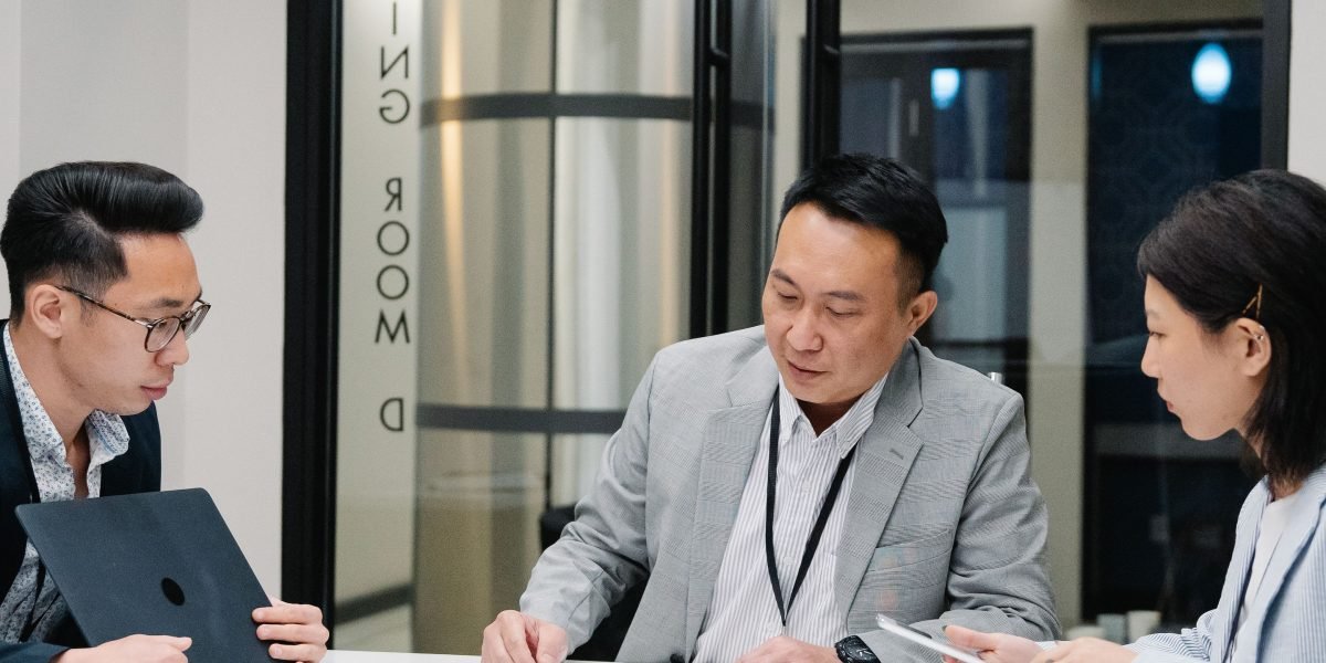 Two professionals engaged in a focused negotiation, possibly discussing terms and pricing for a real estate deal.