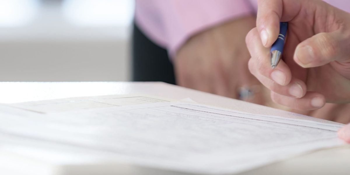 Professionals at a table, finalizing a property deal by signing important legal documents.